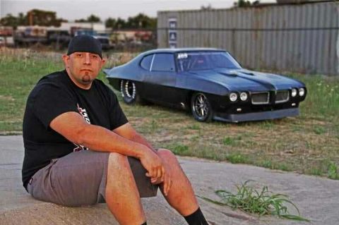Big Chief poses in front of his modified car, The Crow.